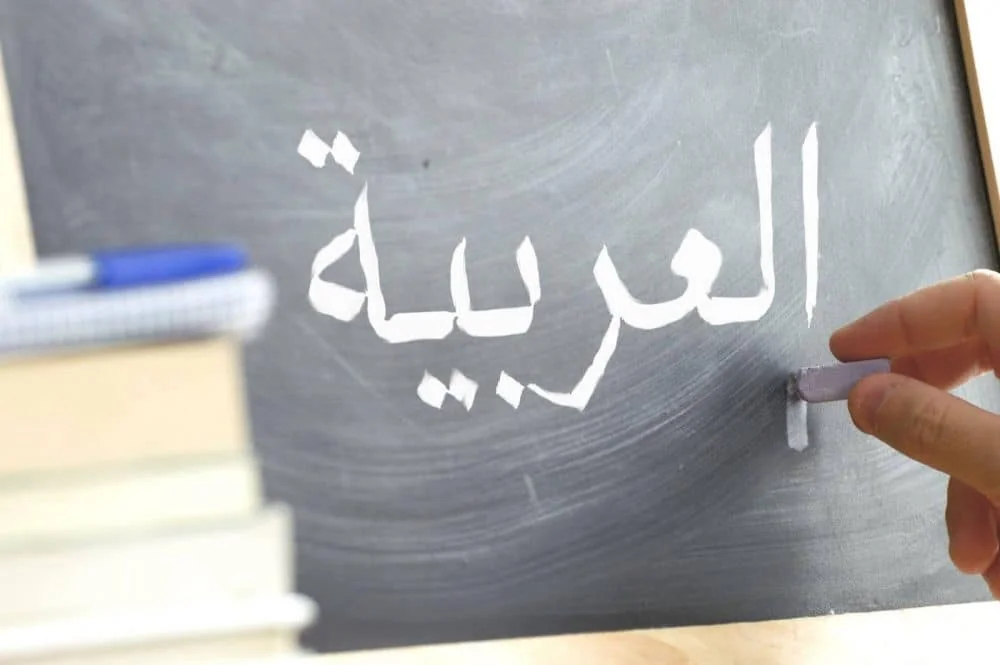 Arabic letters and words written on a classroom blackboard.